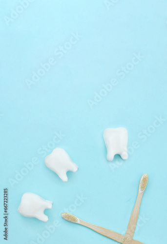Care for oral and dental care concept. Regular checkups are essential to oral health. Flat lay, a clock made of tooth model on a blue background and a toothbrushes and copy space. © Alexa Mat