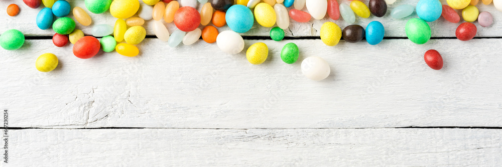 Various kinds of colourful sweets on white wooden table. Top view Various kinds of colourful sweets on white wooden table. Top view