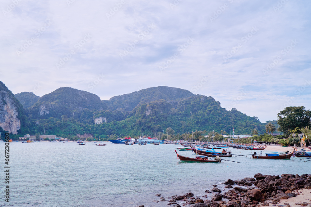 Fototapeta premium Travel by Thailand. Landscape with traditional longtail fishing and tourists boat on the sea beach.