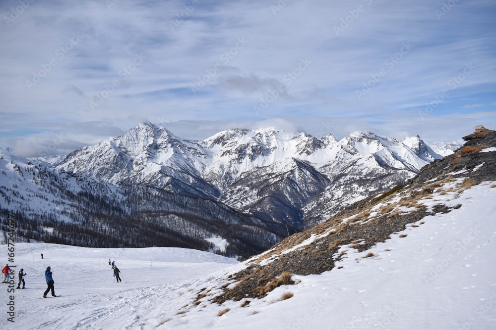 Stunning view of snowy Italian mountain range and valley from ski slope in Sauze D'Oulx ski resort, Turin, Italy. Beautiful Italian alpine peaks of snow capped mountains in the Piedmont region. Stunning view of snowy Italian mountain range and valley from ski slope in Sauze D'Oulx ski resort, Turin, Italy. Beautiful Italian alpine peaks of snow capped mountains in the Piedmont region.