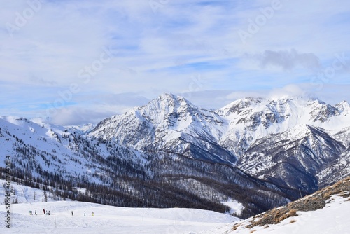 Stunning view of snowy Italian mountain range and valley from ski slope in Sauze D'Oulx ski resort, Turin, Italy. Beautiful Italian alpine peaks of snow capped mountains in the Piedmont region. © Elenitsa