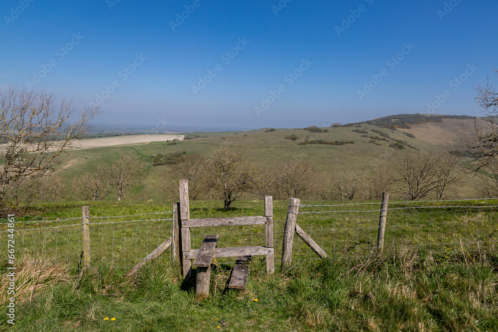 A rural Sussex view with a wooden stile in the foreground