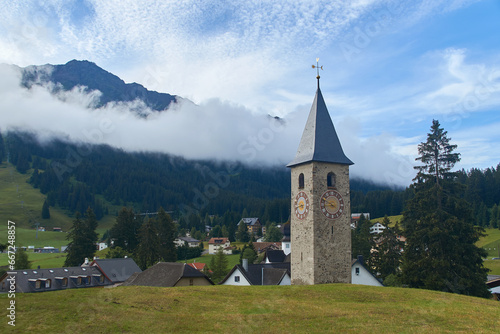 Obraz na płótnie Beautiful swiss alpine countryside with a medieval bell tower with a clock and Rothorn mountain on background in Churwalden village in Switzerland formerly Parpan w salonie