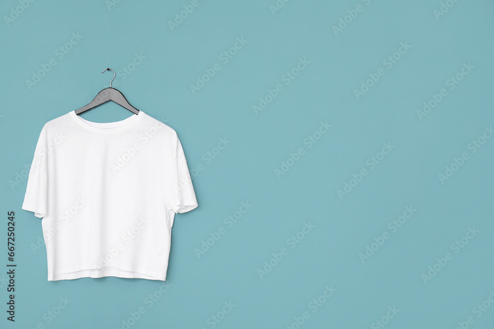 Stylish white t-shirt hanging on blue background Stylish white t-shirt hanging on blue background