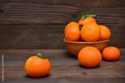 tangerines and fruits in a basket on a dark wooden background