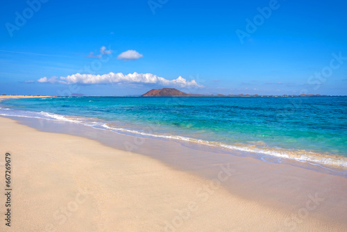 View on Corralejo beach and Lobos island, blue water and golden sand and the Canary Island Fuerteventura, Spain.