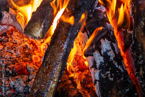  A mesmerizing bonfire exhibiting vibrant red flames in the darkness.