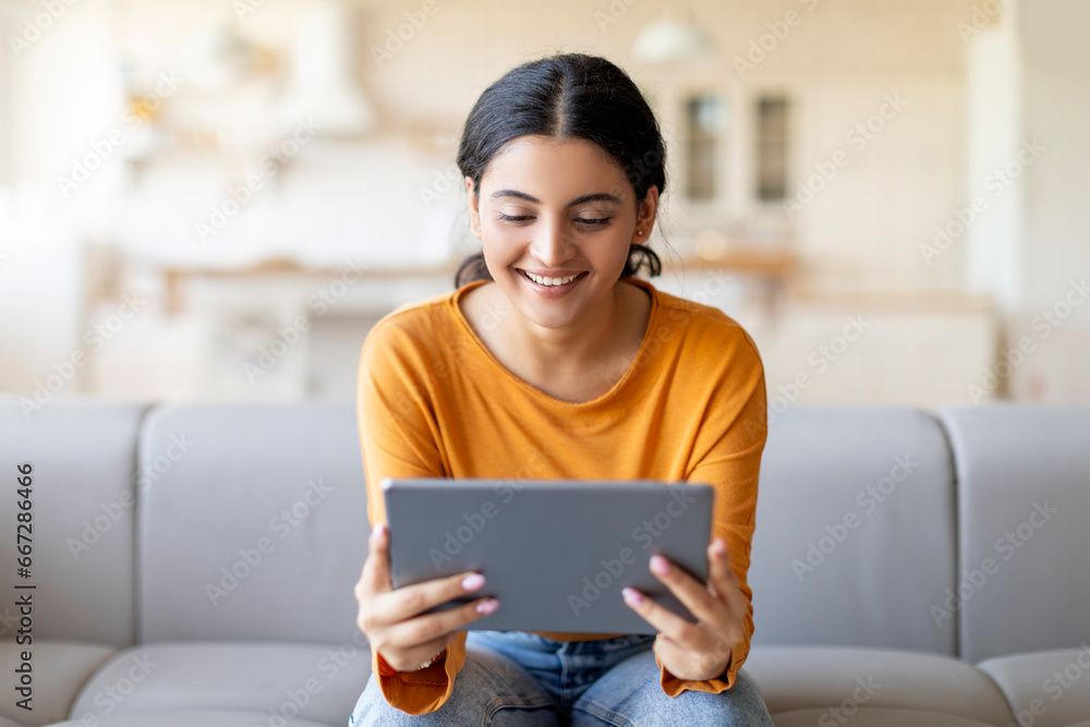 Beautiful young indian woman using digital tablet at home Beautiful young indian woman using digital tablet at home