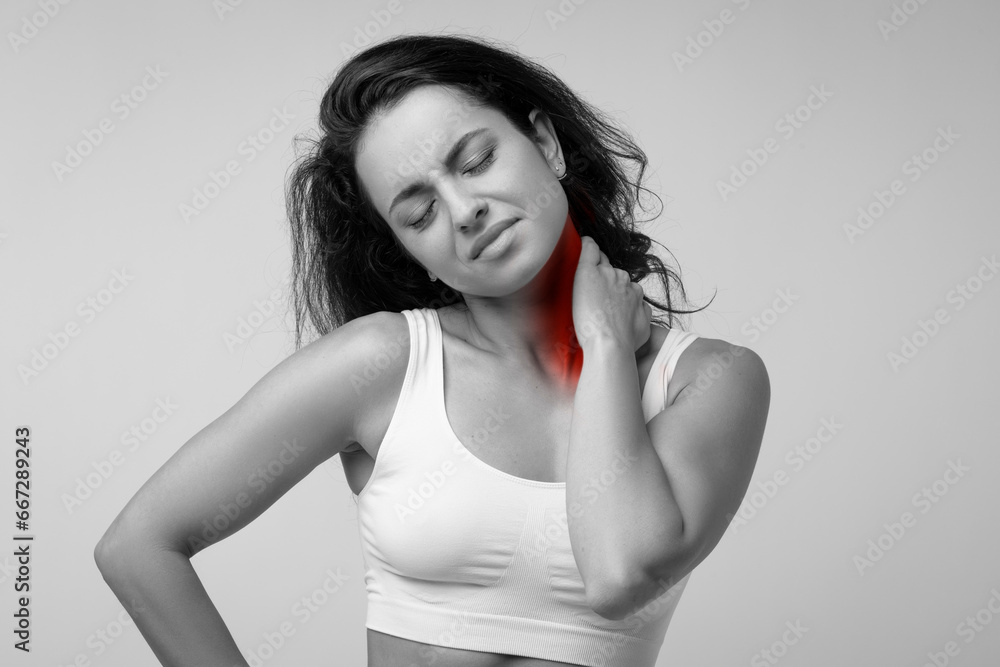 Fototapeta premium Young woman feeling exhausted and suffering from neck pain