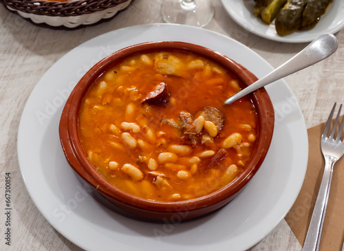 Tasty white bean stew with sausages in bowl, typical spanish dish