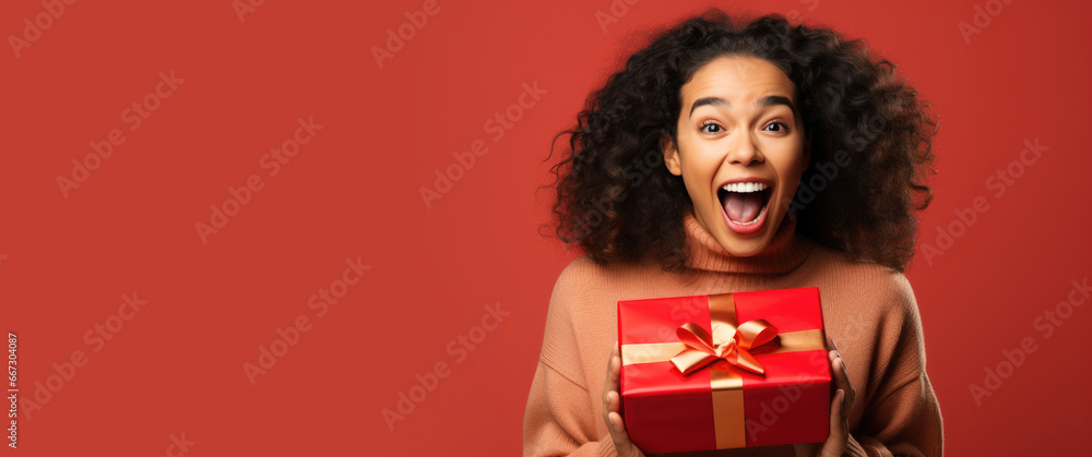 Excited woman opening a present - obrazy, fototapety, plakaty 