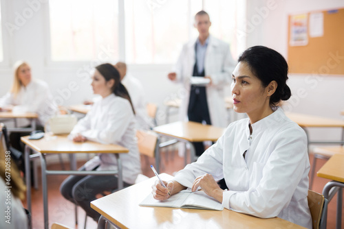 Portrait of confident asian female doctor listening lectures within refresher course. Professional development concept photo