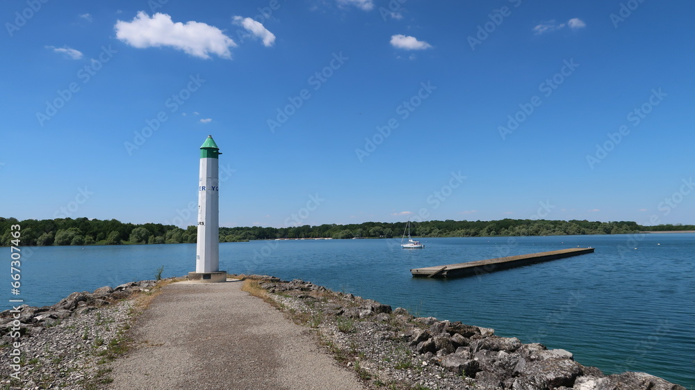Lac du Der Chantecoq, en Champagne Ardenne, dans la région Grand Est, paysage avec le phare du port de Nemours au bout de la jetée, sous un ciel bleu (France)