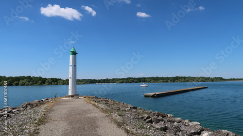 Lac du Der Chantecoq, en Champagne Ardenne, dans la région Grand Est, paysage avec le phare du port de Nemours au bout de la jetée, sous un ciel bleu (France) © Florence Piot