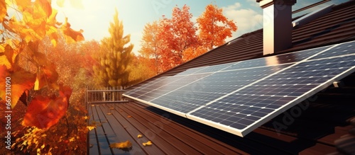 Black solar panels on a house roof gathering sun energy in autumn photo