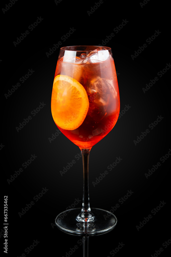 Spritz. This is a Venetian cocktail based on sparkling wine, served as an aperitif in northeastern Italy. It contains Prosecco, a bitter digestif. Drink in a glass on a dark background with reflection Spritz. This is a Venetian cocktail based on sparkling wine, served as an aperitif in northeastern Italy. It contains Prosecco, a bitter digestif. Drink in a glass on a dark background with reflection