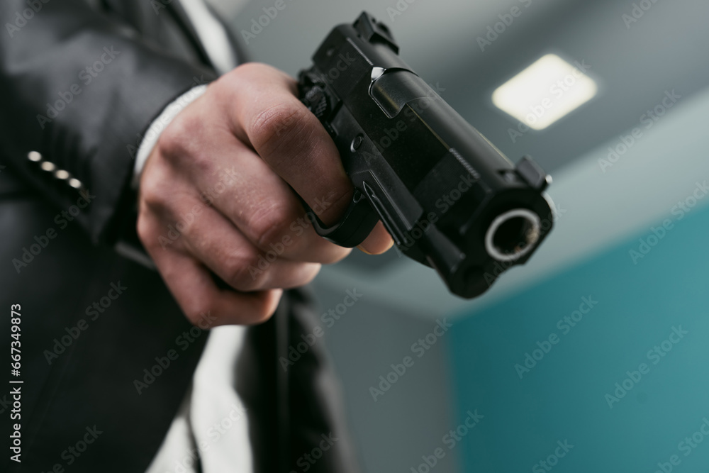 A man in a suit pointed a gun A man in a suit pointed a gun