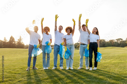 multiracial group of people volunteers in gloves with garbage bags collect garbage and plastic in the park and greet