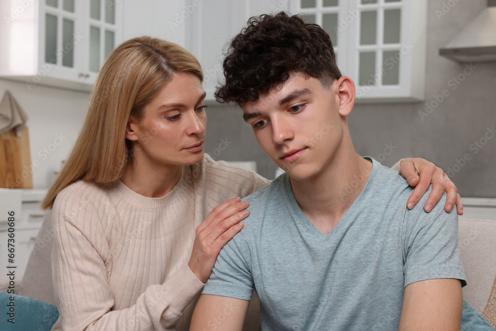 Mother consoling her upset son at home. Teenager problems