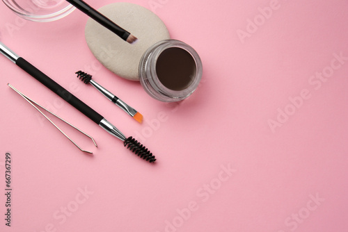 Tableau sur toile Eyebrow pomade with henna effect and professional tools on pink background, flat lay