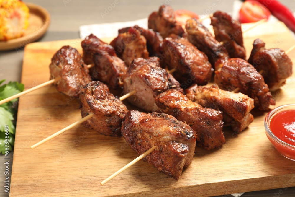 Skewers with delicious shish kebabs on table, closeup