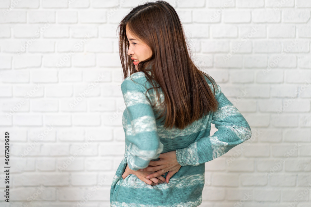 Woman unhappy holding back pain with suffering from backache, Lower back pain, office syndrome, muscle spasm, musculotendinous strain, hurt, massage, Woman healthcare Woman unhappy holding back pain with suffering from backache, Lower back pain, office syndrome, muscle spasm, musculotendinous strain, hurt, massage, Woman healthcare