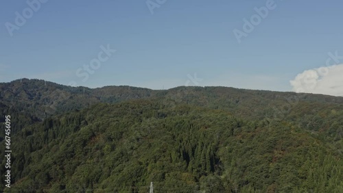 ドローン映像：青空と、紅葉が始まった山