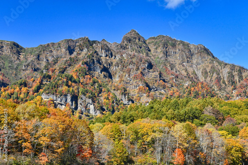 澄み切った青空にそびえる紅葉の戸隠連山