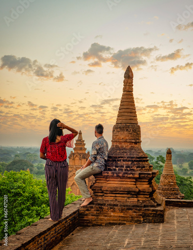 a couple visit Bagan Myanmar, Sunrise above temples and pagodas of Bagan Myanmar, Sunrise Pagan Myanmar temple and pagoda. Men and women at an old pagoda during vacation in Myanmar