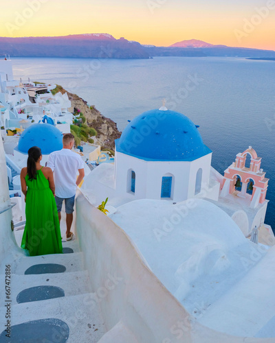 A couple of men and woman on vacation in Greece visited the village of Oia Santorini during sunset, a mature couple on a luxury holiday in Greece visited the Mediterranean Cyclades