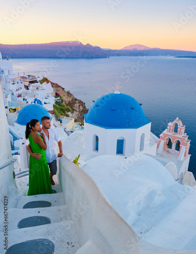 A couple of men and woman on vacation in Greece visited the village of Oia Santorini during sunset, a mature couple on a luxury holiday in Greece Santorini