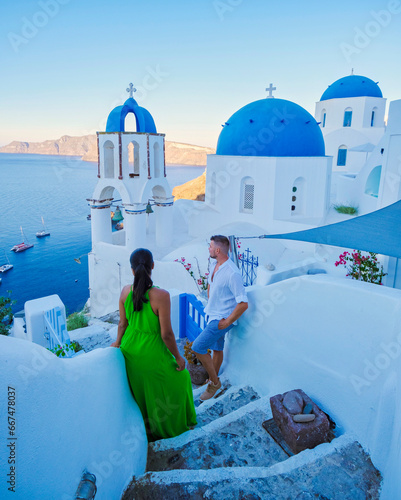 a couple of men and women on vacation in Santorini Greece. young couple on vacation in Greece Santorini watching the sunrise over the ocean at the narrow streets of the village of Oia 