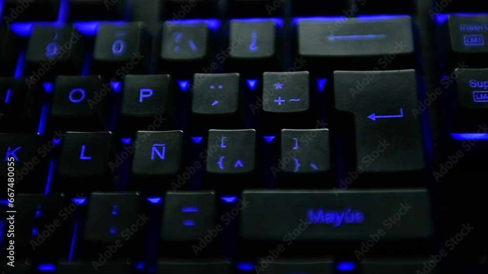 Man's hand pressing the ENTER key on a blue backlit black computer keyboard. selective focus. Man's hand pressing the ENTER key on a blue backlit black computer keyboard. selective focus.