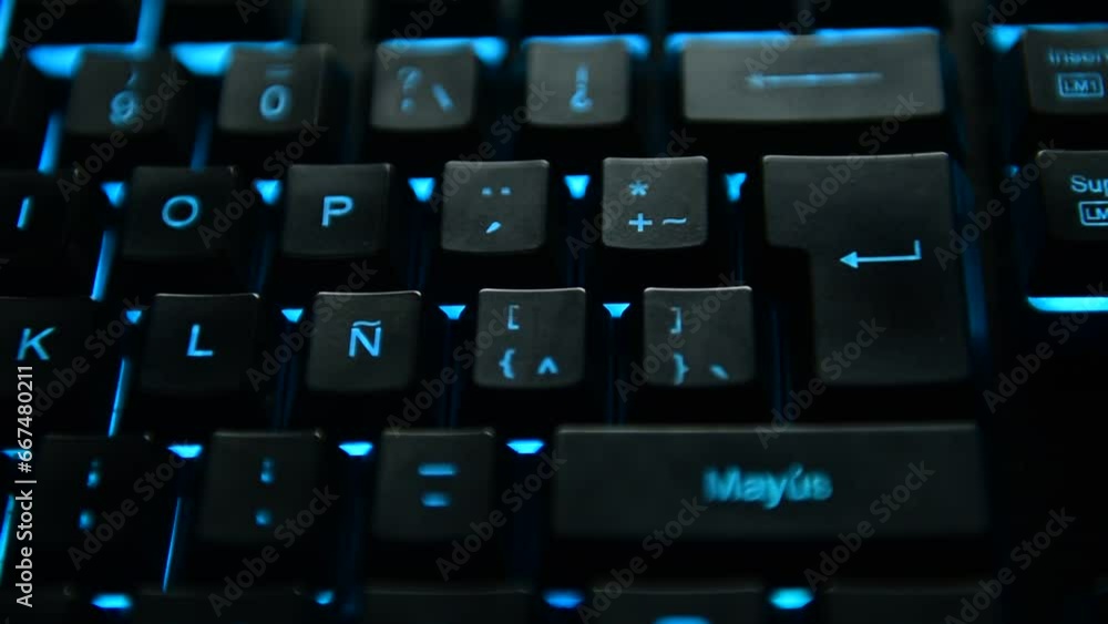 Man's hand pressing the ENTER key on a sky blue backlit black computer keyboard. selective focus. Man's hand pressing the ENTER key on a sky blue backlit black computer keyboard. selective focus.
