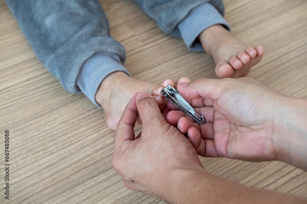 The hands of a mother cutting her child's toenails The hands of a mother cutting her child's toenails