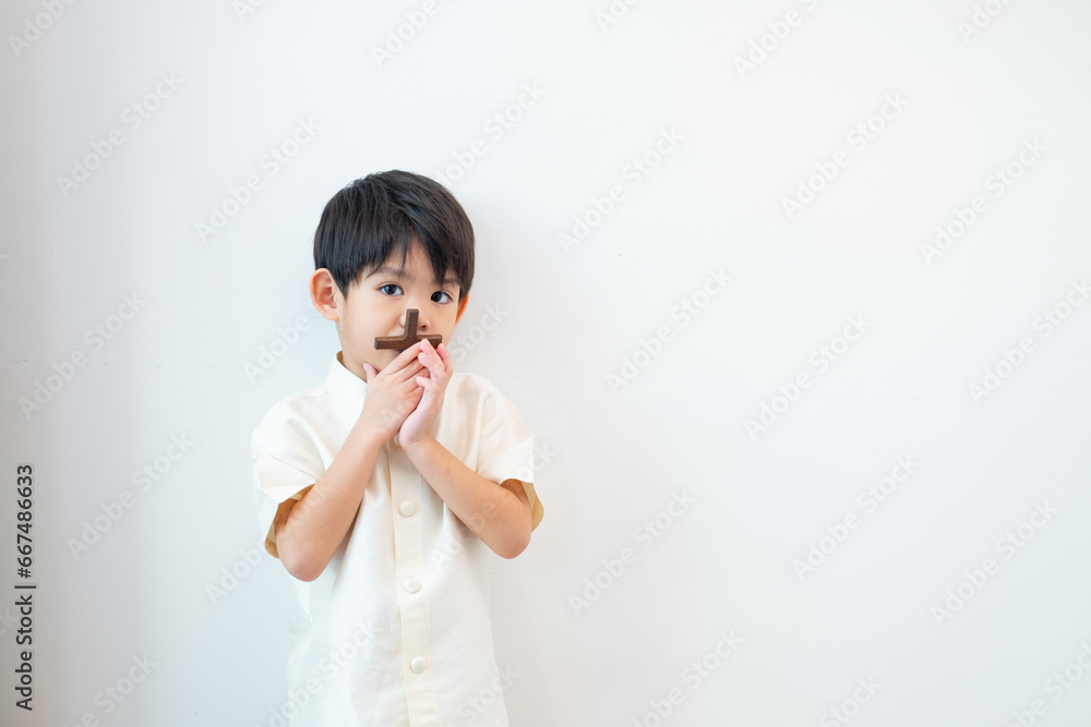 Little Asian boy praying with holding the cross, Christian concept Little Asian boy praying with holding the cross, Christian concept