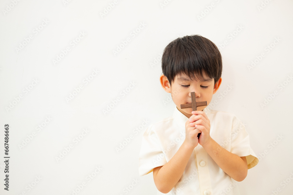 Little Asian boy praying with holding the cross, Christian concept Little Asian boy praying with holding the cross, Christian concept
