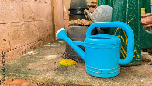 Watering can placed on a cement platform. © Thebt