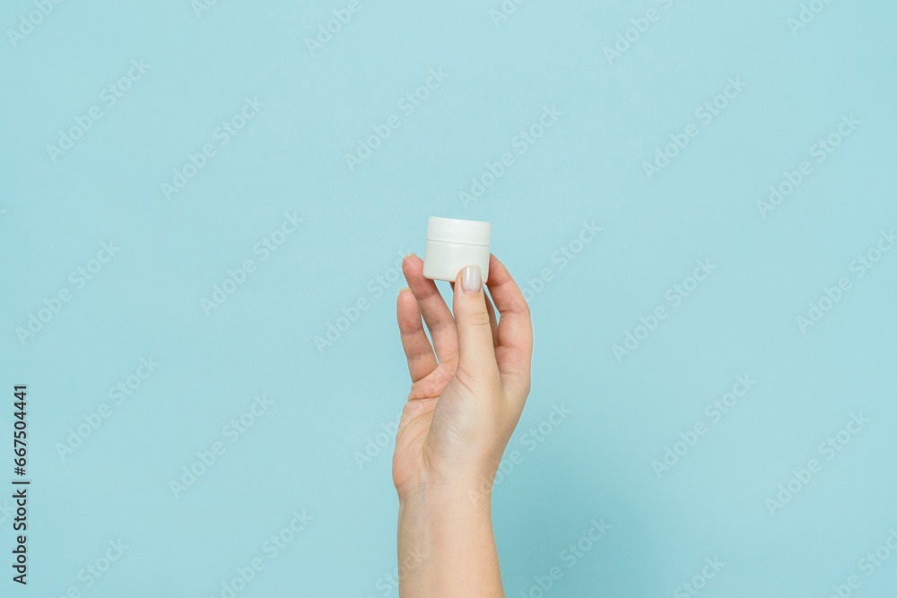 Woman's hand holding jar of cream or ointment. Packaging cosmetic product Woman's hand holding jar of cream or ointment. Packaging cosmetic product