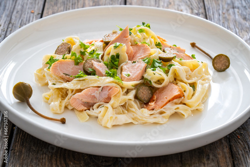 Tagliatelle with salmon and mayonnaise on wooden table 