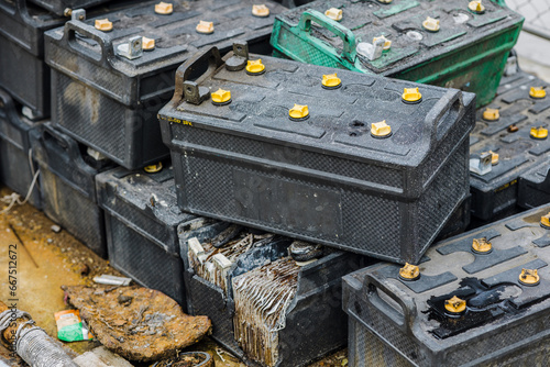 Battery waste. Pile of old used EV car batteries toxic waste chemicals lead leak impact nature no recycled.