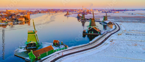Zaanse Schans Netherlands a Dutch windmill village during sunrise at winter with a snowy landscape, winter snow at the historical windmill village near Amsterdam photo