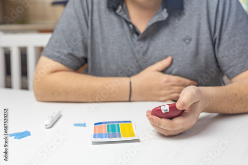Unpleasantly surprised man looks at the results of blood sugar level measurement. Horizontally. 