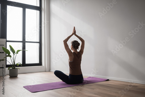 Young beautiful woman practicing yoga in yoga studio. Young beautiful girl doing exercises at home. Harmony, balance, meditation, self-care, relaxation, healthy lifestyle, mindfulness concept