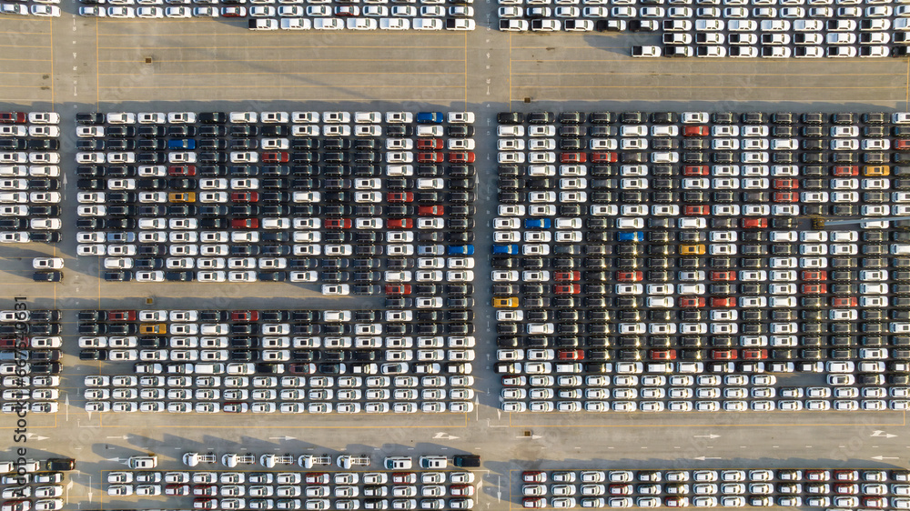 Aerial view new ev car on car park, Ev car loading, EV new cars stock at factory parking lot, Automotive industry, Logistics business. Import or export new cars at warehouse, Parking lot at port.