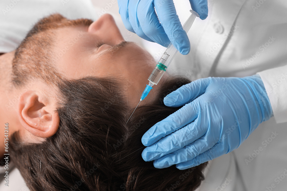 Trichologist giving injection to patient in clinic, closeup Trichologist giving injection to patient in clinic, closeup