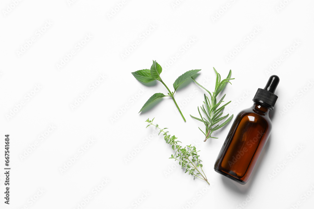 Bottle of essential oil and different herbs on white background, flat lay. Space for text Bottle of essential oil and different herbs on white background, flat lay. Space for text