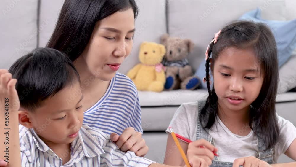 Multitasking mother teaching homework counting number for cute sibling elementary school children, Asian mom take care kids enjoy playtime drawing pictures activity sitting on sofa together in weekend Multitasking mother teaching homework counting number for cute sibling elementary school children, Asian mom take care kids enjoy playtime drawing pictures activity sitting on sofa together in weekend