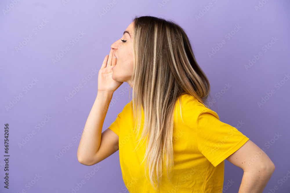Young woman over isolated purple background shouting with mouth wide open to the side Young woman over isolated purple background shouting with mouth wide open to the side