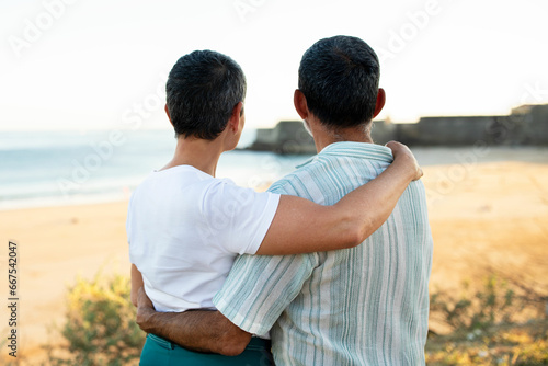 Senior Couple Embracing Sharing Love Standing At Ocean View Outside